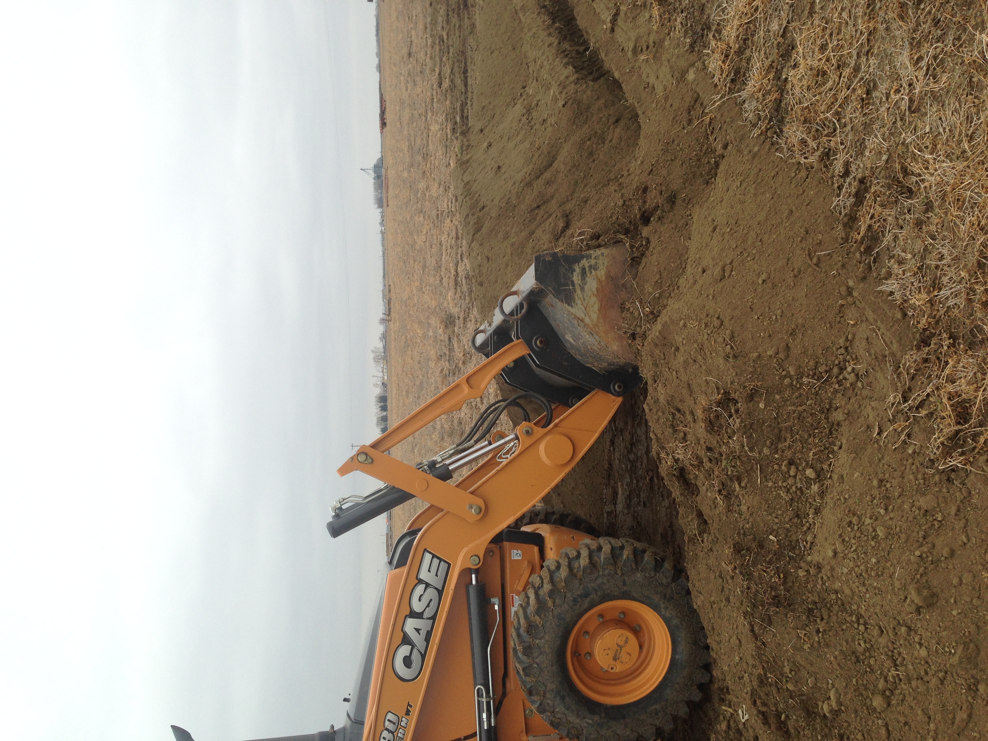 Backhoe covering installed water line - Boonco Excavating